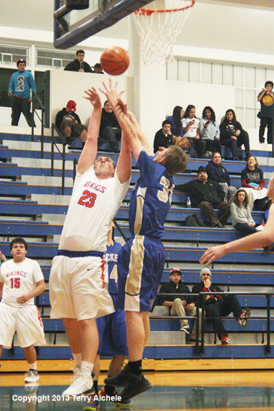 LEFT - Aaron Simmons of Umatilla, in white, takes a shot while being ...